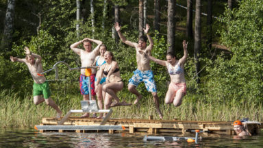 Nuoret hyppäävät laiturilta veteen.